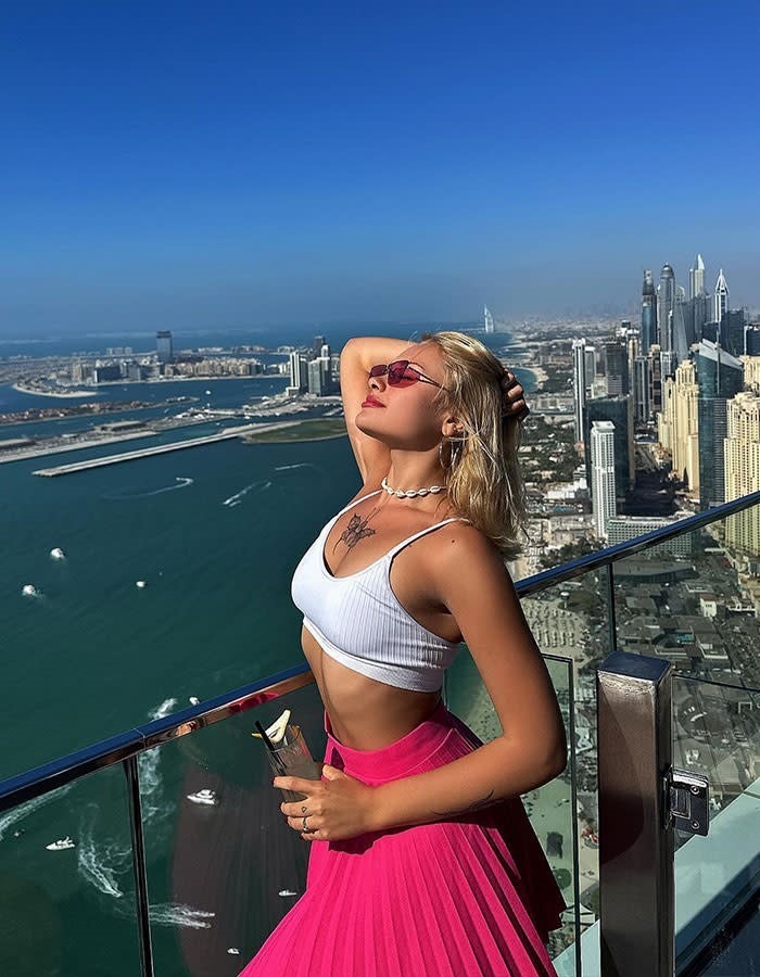 Ukrajinska manekenka koja je pretučena u Dubaiju prekinula tišinu 2 Model in vibrant outfit posing on a high-rise balcony overlooking a vast cityscape.Image credits: Getty Images / Unslplash