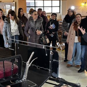 Grupa turista sluša objašnjenja kustosa pored stare kočije u Muzeju kočija na Ergeli Kelebija, Subotica.