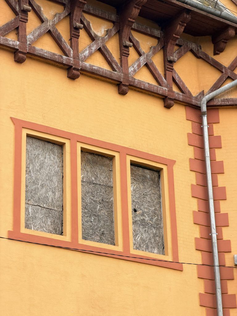 Detalj lučnih prozora na vili Bogojvar, drvena konstrukcija i fasada u žuto-crvenim tonovima.